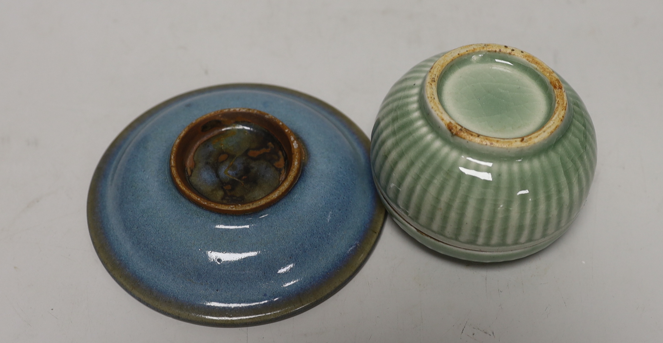 Two Yixing teapots, a celadon glazed circular box and Jun type saucer, 12cm diameter